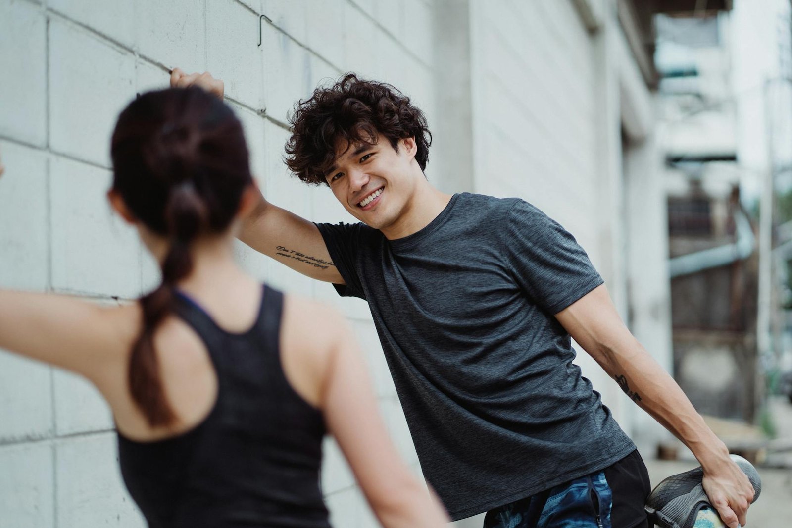 https://www.pexels.com/photo/photo-of-a-man-and-woman-stretching-by-the-wall-4853038/