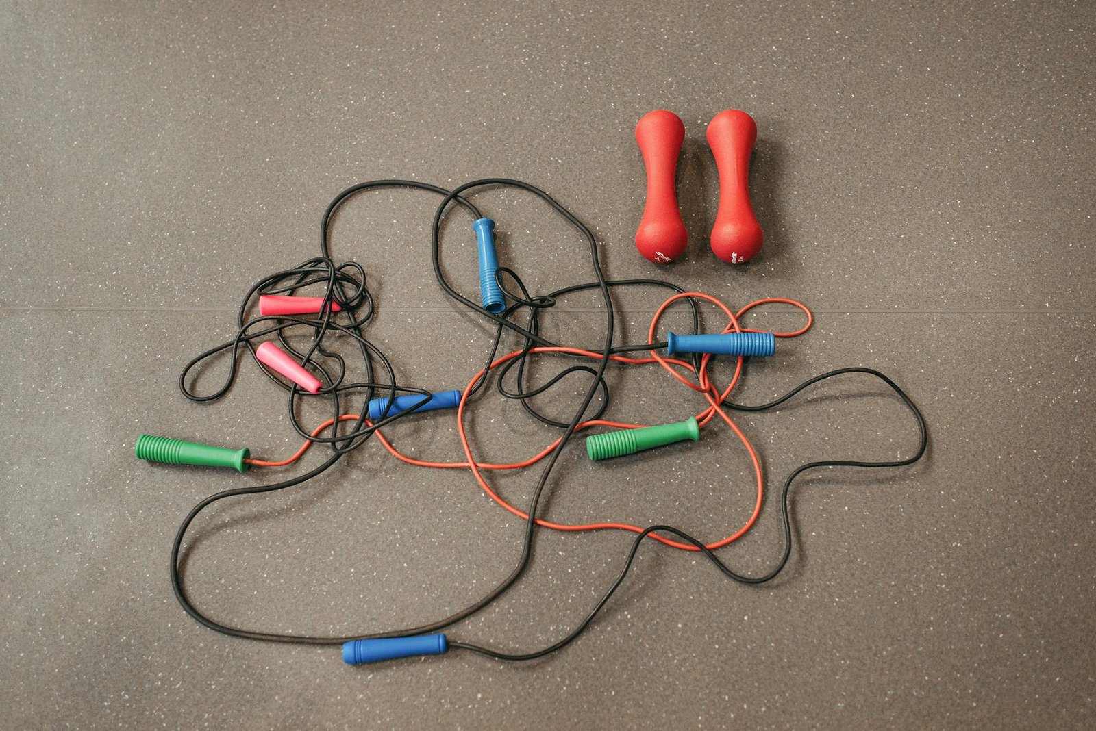 https://www.pexels.com/photo/jumping-ropes-and-dumbbells-on-gray-surface-6339678/